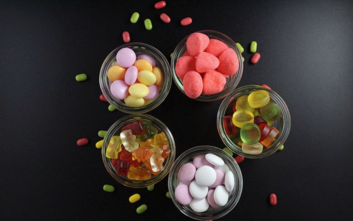 Una bolsa de gominolas de colores en plato de cerámica